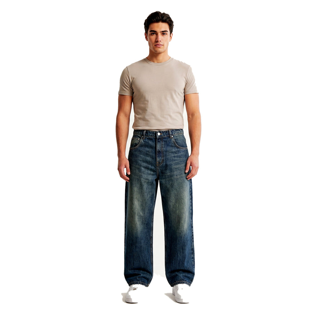 Male model wearing embroidered wide-leg baggy jeans in a medium wash, Y2K streetwear