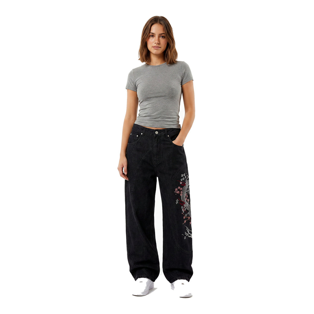 Female model in embroidered baggy Y2K jeans, dark wash, wide-leg streetwear fit
