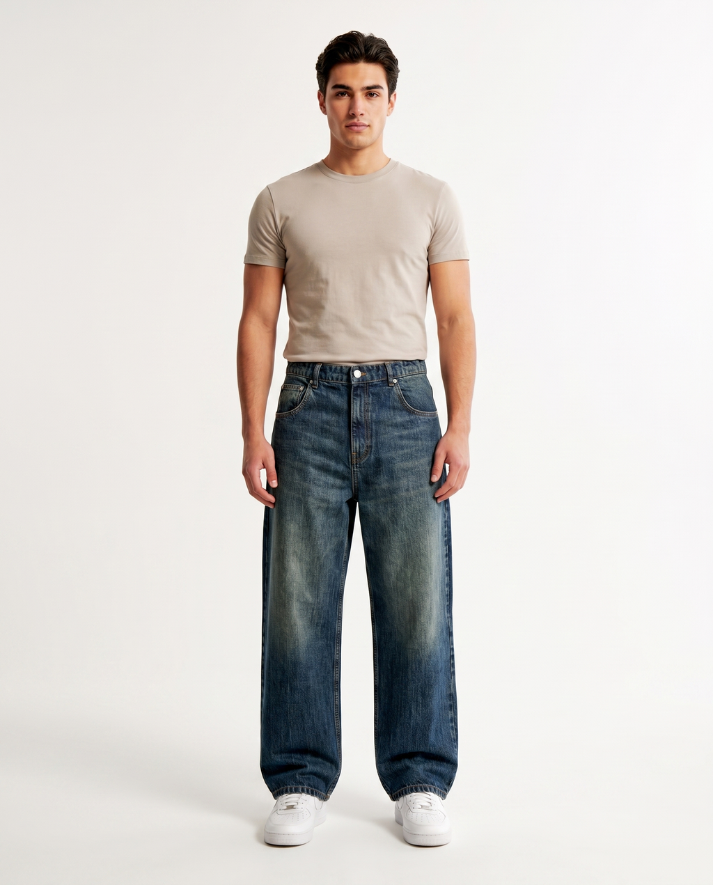 Male model wearing embroidered wide-leg baggy jeans in a medium wash, Y2K streetwear