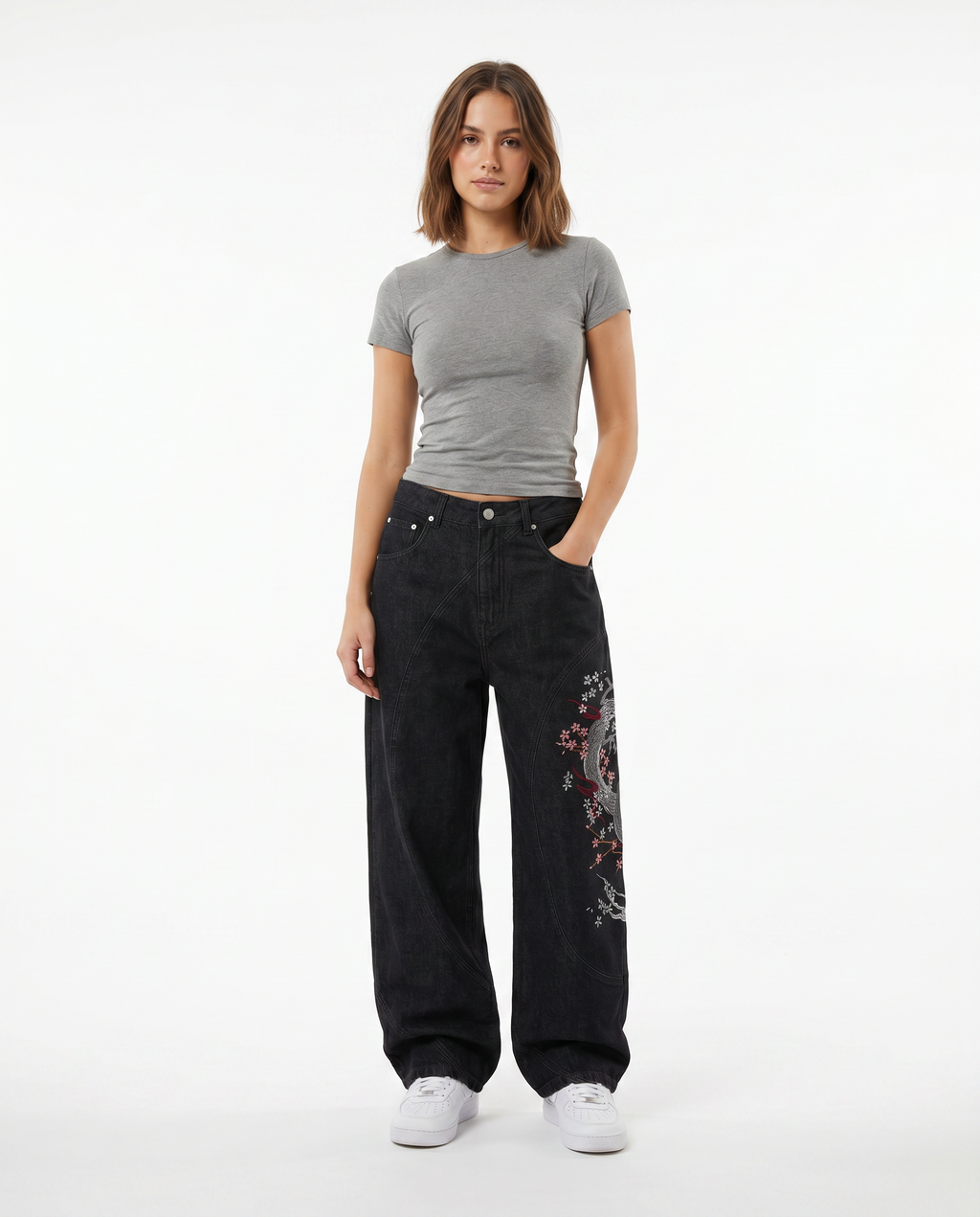 Female model in embroidered baggy Y2K jeans, dark wash, wide-leg streetwear fit