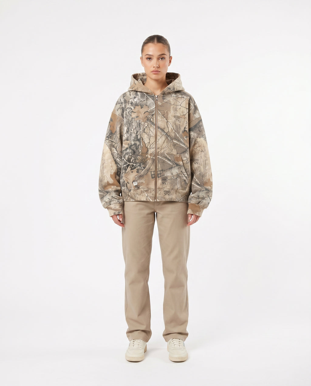 Female model wearing the camo oversized zip-up hoodie